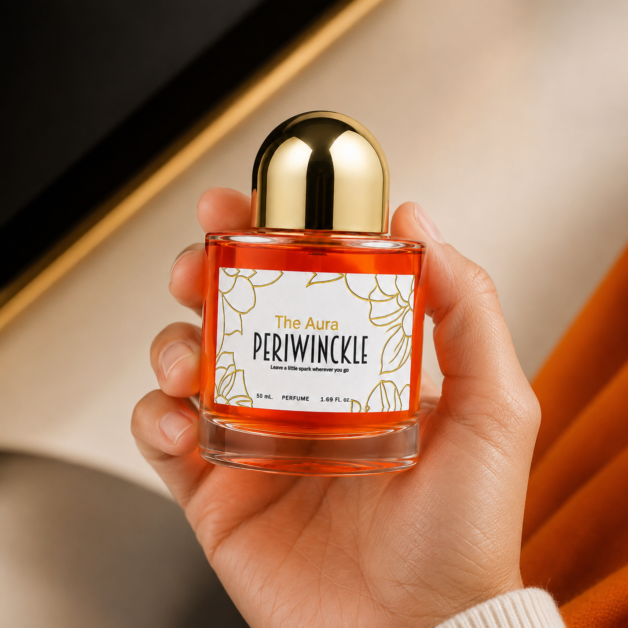 The Aura 50ml Periwinckle parfum bottle held in hand for scale