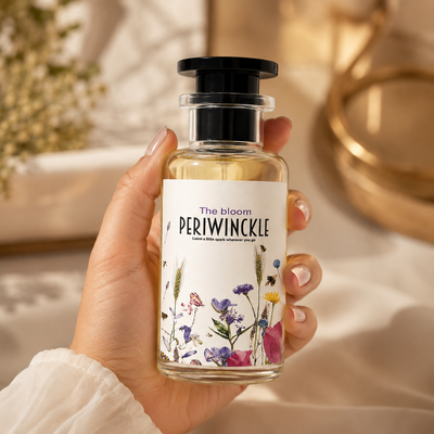 The Bloom 50ml Periwinckle parfum bottle held in hand for scale